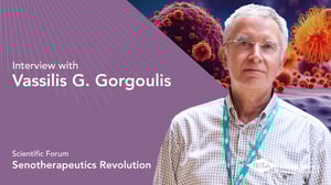Vassilis G. Gorgoulis foto ritratto. Lo sfondo mostra un'immagine stilizzata di cellule, con il testo “Forum scientifico – Rivoluzione senoterapeutica” su un pannello viola.