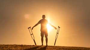Man letting go of crutches able to walk again.
