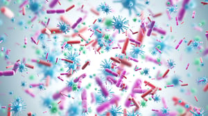 Virus rosa e blu e batteri di varie forme su uno sfondo blu.
