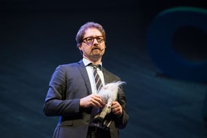 Telmo Pievani con in mano un gioco di pezza ad una conferenza